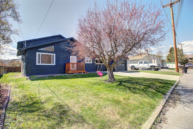 exterior space featuring a garage, fence, concrete driveway, and a lawn