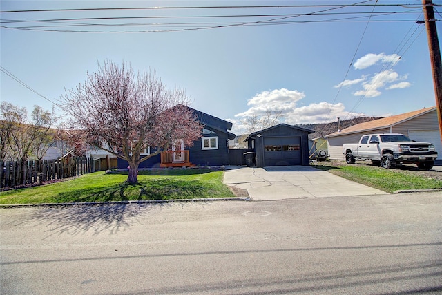 view of front of property with fence, a front yard, and concrete driveway