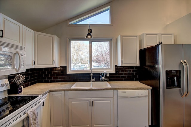 kitchen with white appliances, decorative backsplash, vaulted ceiling, white cabinets, and a sink