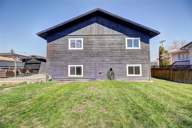 back of property featuring fence, a yard, and a patio