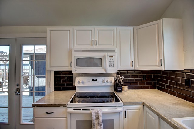 kitchen with light countertops, white cabinets, tasteful backsplash, and white appliances