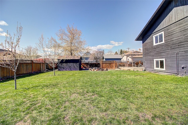 view of yard featuring an outbuilding, a shed, and a fenced backyard