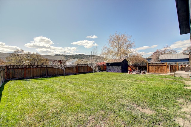 view of yard featuring an outbuilding, a shed, and a fenced backyard