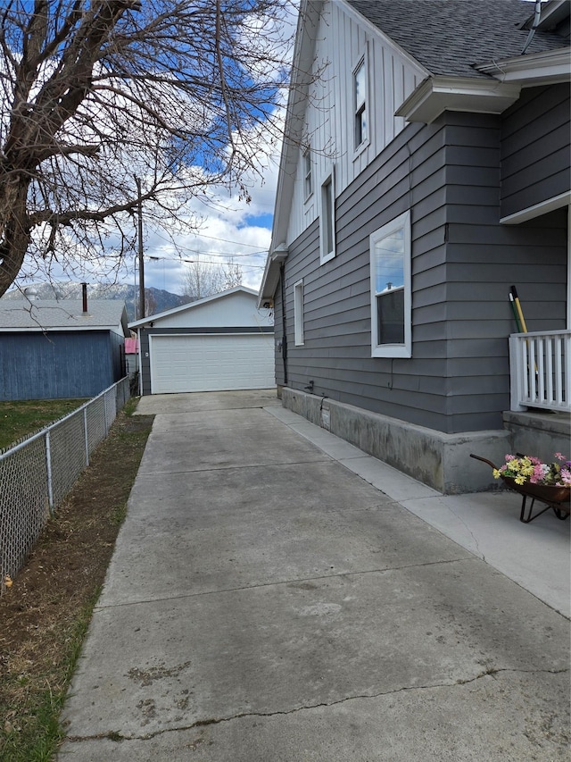 1512 Gaylord St, Butte, MT 59701 - view of side of home with board and batten siding, fence, an outbuilding, roof with shingles, and a detached garage