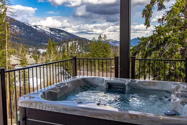 wooden deck featuring a mountain view and a hot tub