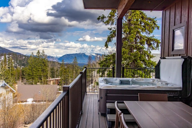 balcony with a covered hot tub and a mountain view