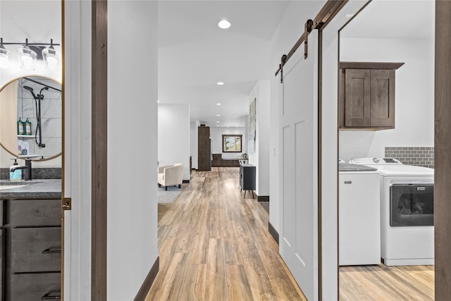 270 Westridge Dr, Somers, MT 59932 - corridor with a barn door, washer and dryer, light wood-style floors, and recessed lighting