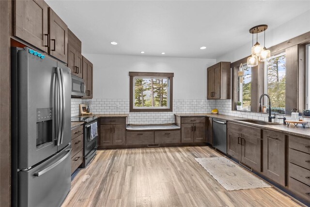 270 Westridge Dr, Somers, MT 59932 - kitchen with stainless steel appliances, decorative backsplash, light wood-style flooring, and a sink