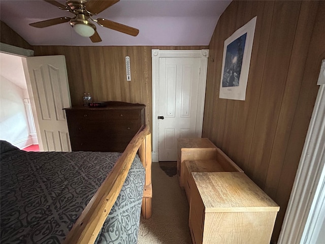 bedroom featuring carpet flooring, wood walls, ceiling fan, and lofted ceiling