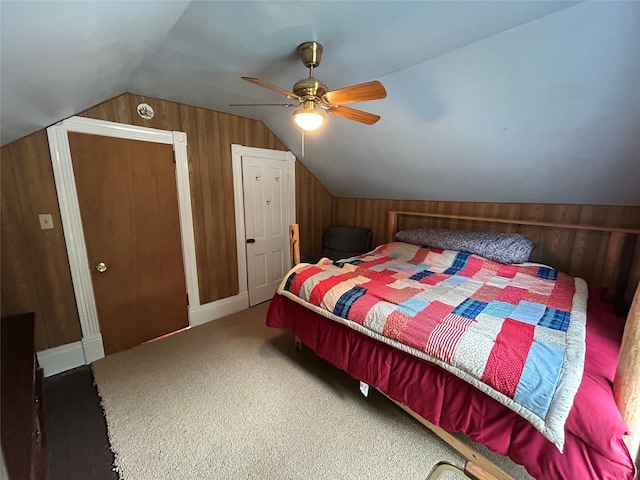 carpeted bedroom with wooden walls, a ceiling fan, and vaulted ceiling
