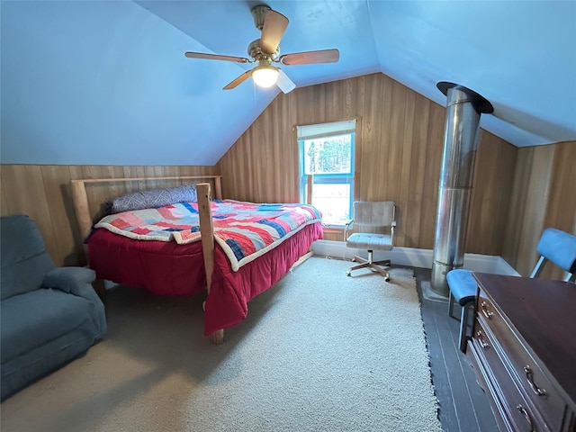 bedroom featuring wood walls, carpet, ceiling fan, and vaulted ceiling