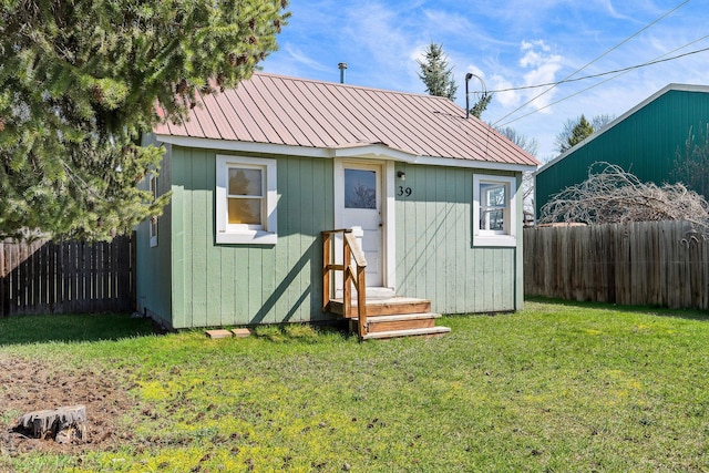 view of outdoor structure with a fenced backyard and an outbuilding