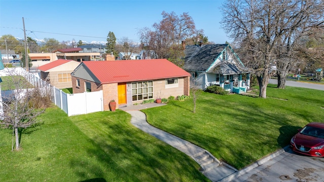 ranch-style house with fence, metal roof, a residential view, and a front lawn