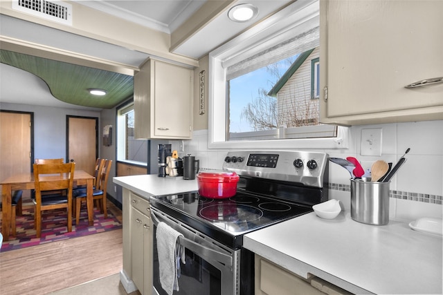 kitchen featuring backsplash, visible vents, light countertops, and stainless steel electric range