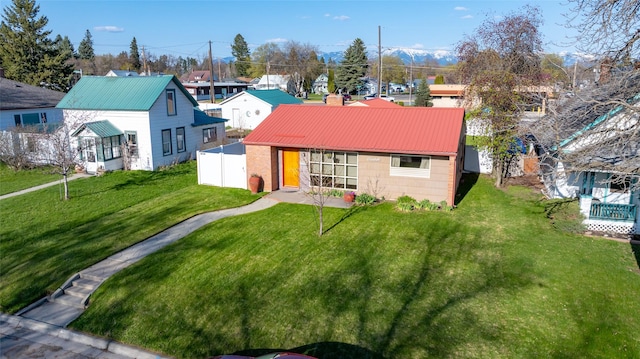 back of property with fence, a residential view, metal roof, and a yard