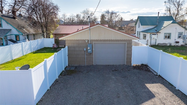 detached garage featuring gravel driveway and fence