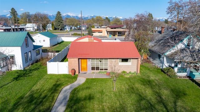 rear view of property with a residential view, a lawn, fence, and brick siding