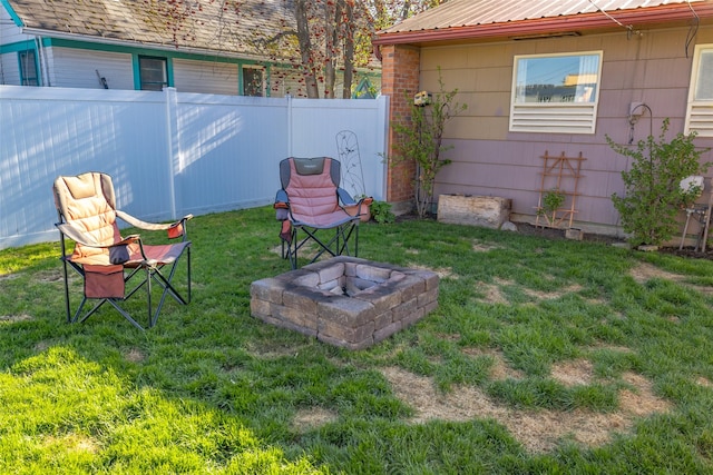 view of yard with fence and an outdoor fire pit
