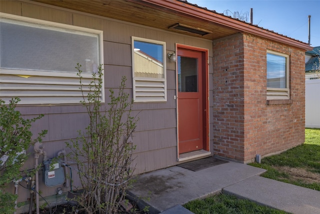 doorway to property featuring brick siding