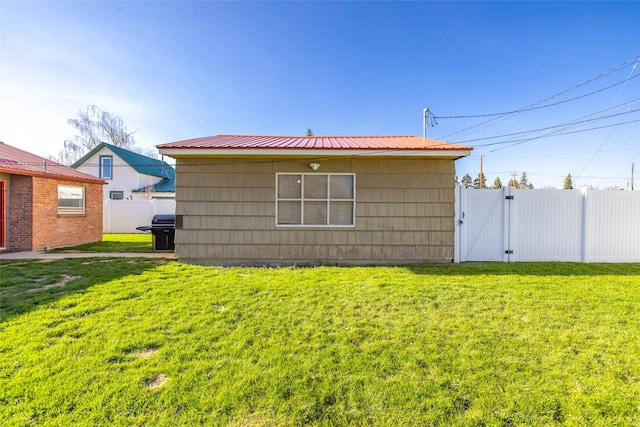 view of outbuilding featuring fence and a gate