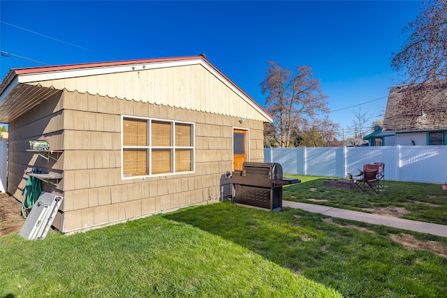 view of side of property with fence and a yard