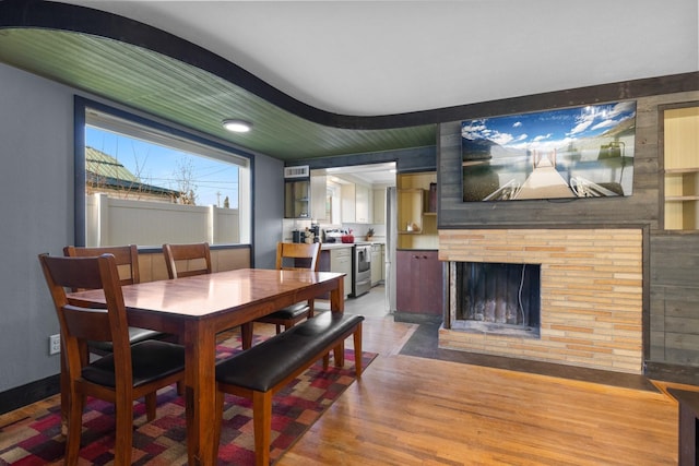 dining space featuring visible vents, light wood-style flooring, and a fireplace