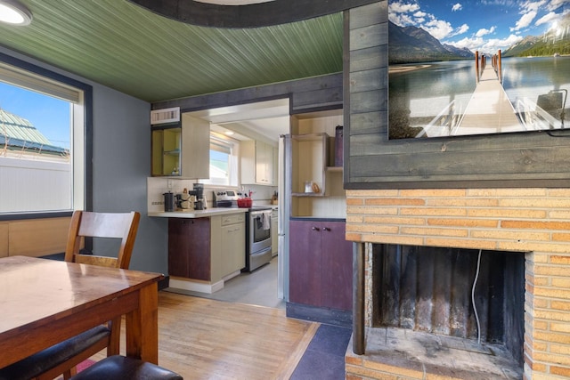 kitchen featuring visible vents, stainless steel electric stove, and a fireplace