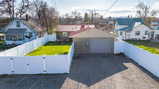 view of front of house featuring a garage, a gate, driveway, and a fenced backyard