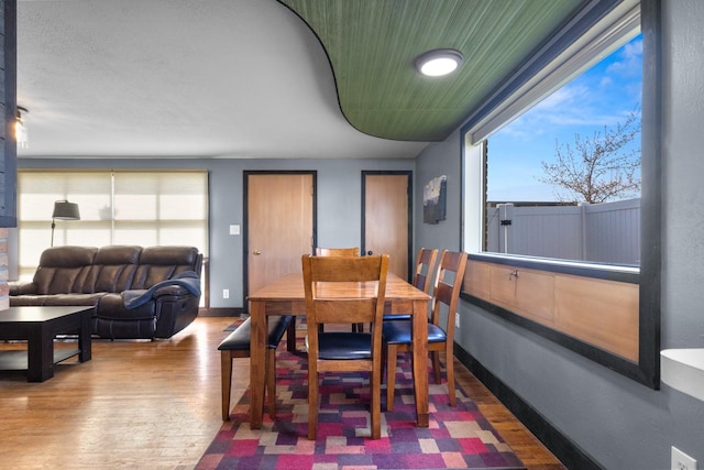 dining space with baseboards and wood finished floors