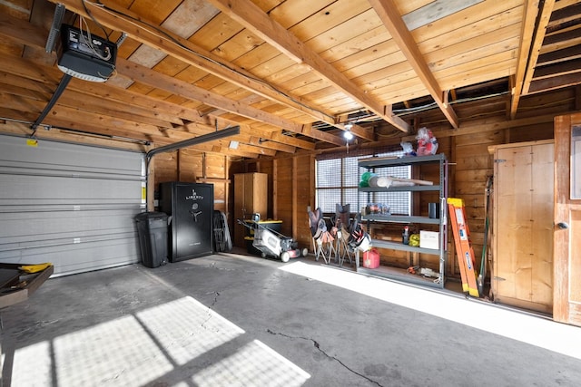 garage with wood ceiling, a garage door opener, wooden walls, and a workshop area