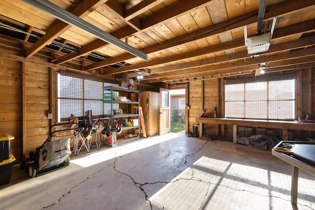misc room with wooden walls, a workshop area, and concrete flooring