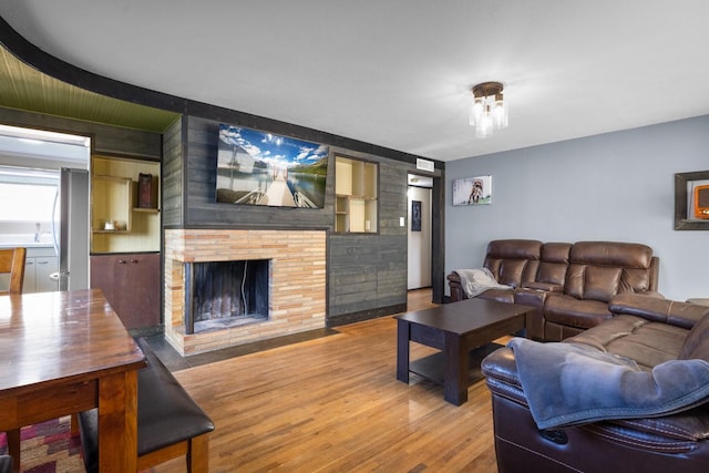 living area featuring wood finished floors and a brick fireplace