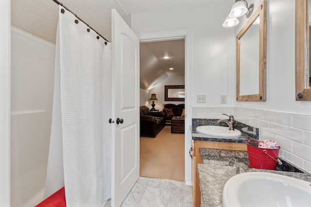 ensuite bathroom featuring lofted ceiling, connected bathroom, a shower with curtain, recessed lighting, and vanity