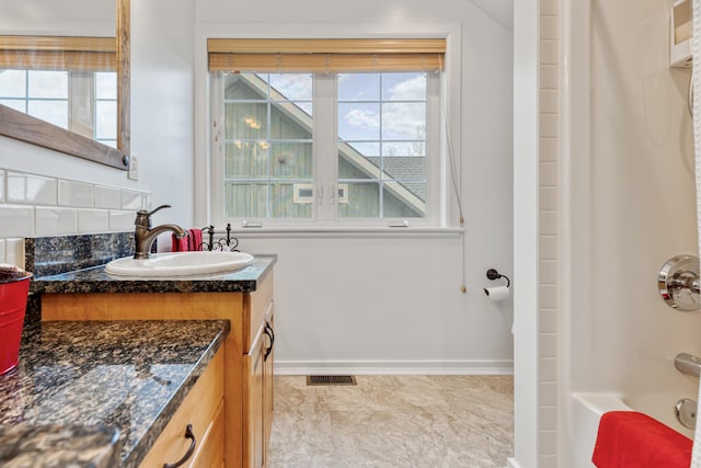 bathroom with baseboards, visible vents, shower / tub combination, and vanity