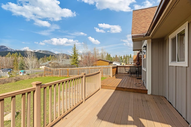 deck featuring a yard, a mountain view, and a fenced backyard