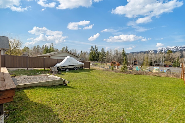 view of yard featuring a mountain view and fence