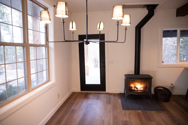 entryway with a wood stove, wood finished floors, and baseboards