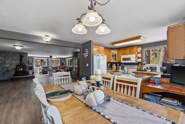 dining area featuring a wood stove and dark wood finished floors