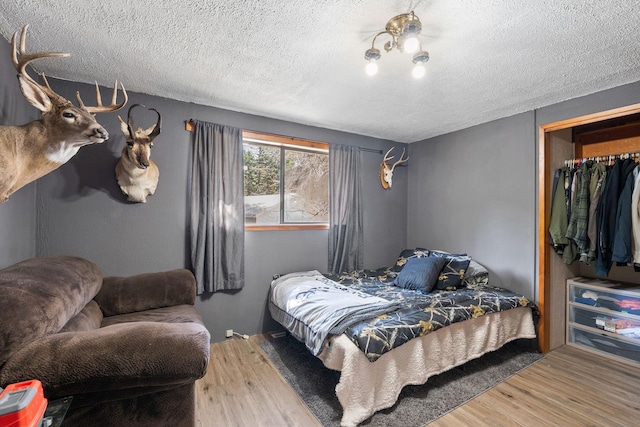 bedroom featuring wood finished floors and a textured ceiling