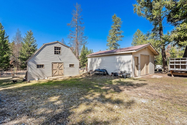 rear view of property with a barn, an outbuilding, and metal roof