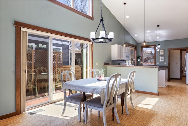 3383 Sora Way, Bozeman, MT 59718 - dining space featuring healthy amount of natural light, a chandelier, light wood-type flooring, and high vaulted ceiling