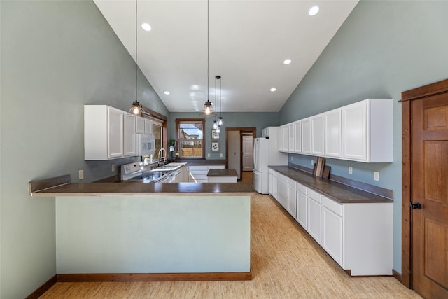 3383 Sora Way, Bozeman, MT 59718 - kitchen with white appliances, high vaulted ceiling, a peninsula, dark countertops, and white cabinetry
