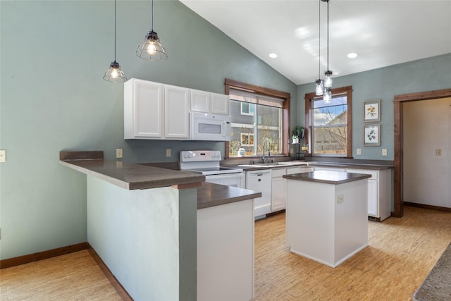 3383 Sora Way, Bozeman, MT 59718 - kitchen featuring white appliances, a peninsula, dark countertops, white cabinets, and light wood-style flooring