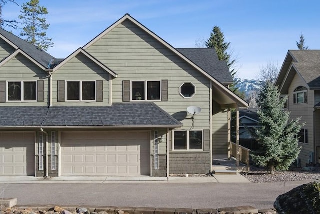 view of front of property with a garage and roof with shingles