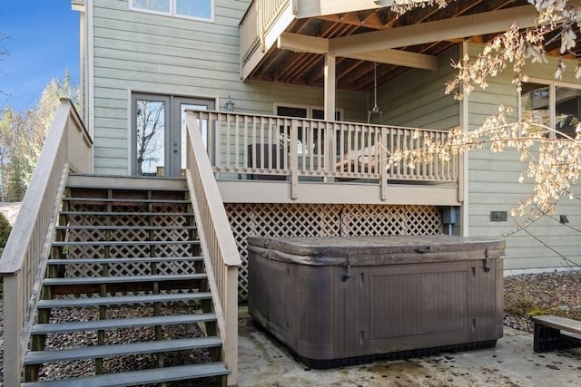 exterior space featuring a deck, stairs, and a hot tub