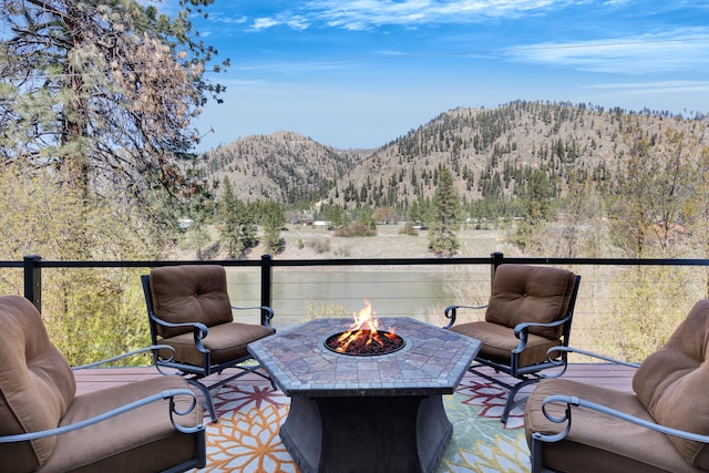 390 Dairy Ln, Superior, MT 59872 - balcony featuring a fire pit, a mountain view, and a view of trees