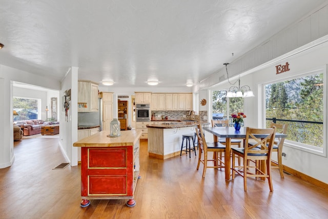 390 Dairy Ln, Superior, MT 59872 - kitchen with oven, healthy amount of natural light, wood finished floors, and cream cabinets