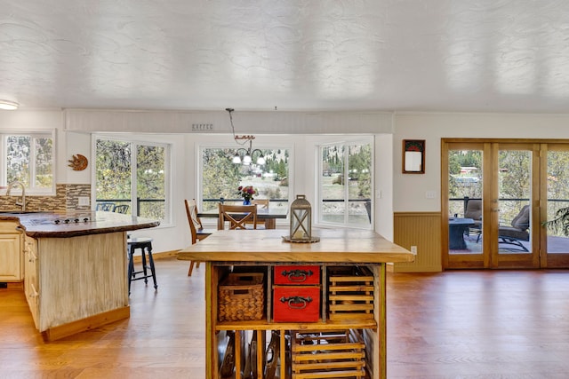 390 Dairy Ln, Superior, MT 59872 - dining room featuring light wood finished floors, plenty of natural light, wainscoting, and a chandelier