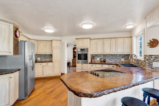 390 Dairy Ln, Superior, MT 59872 - kitchen with appliances with stainless steel finishes, a sink, a peninsula, tasteful backsplash, and a kitchen breakfast bar