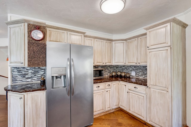 390 Dairy Ln, Superior, MT 59872 - kitchen featuring appliances with stainless steel finishes, decorative backsplash, light wood-style flooring, and dark stone counters
